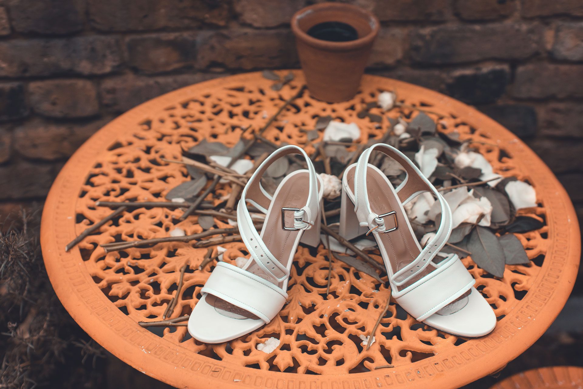 the wedding shoes sitting on an orange table