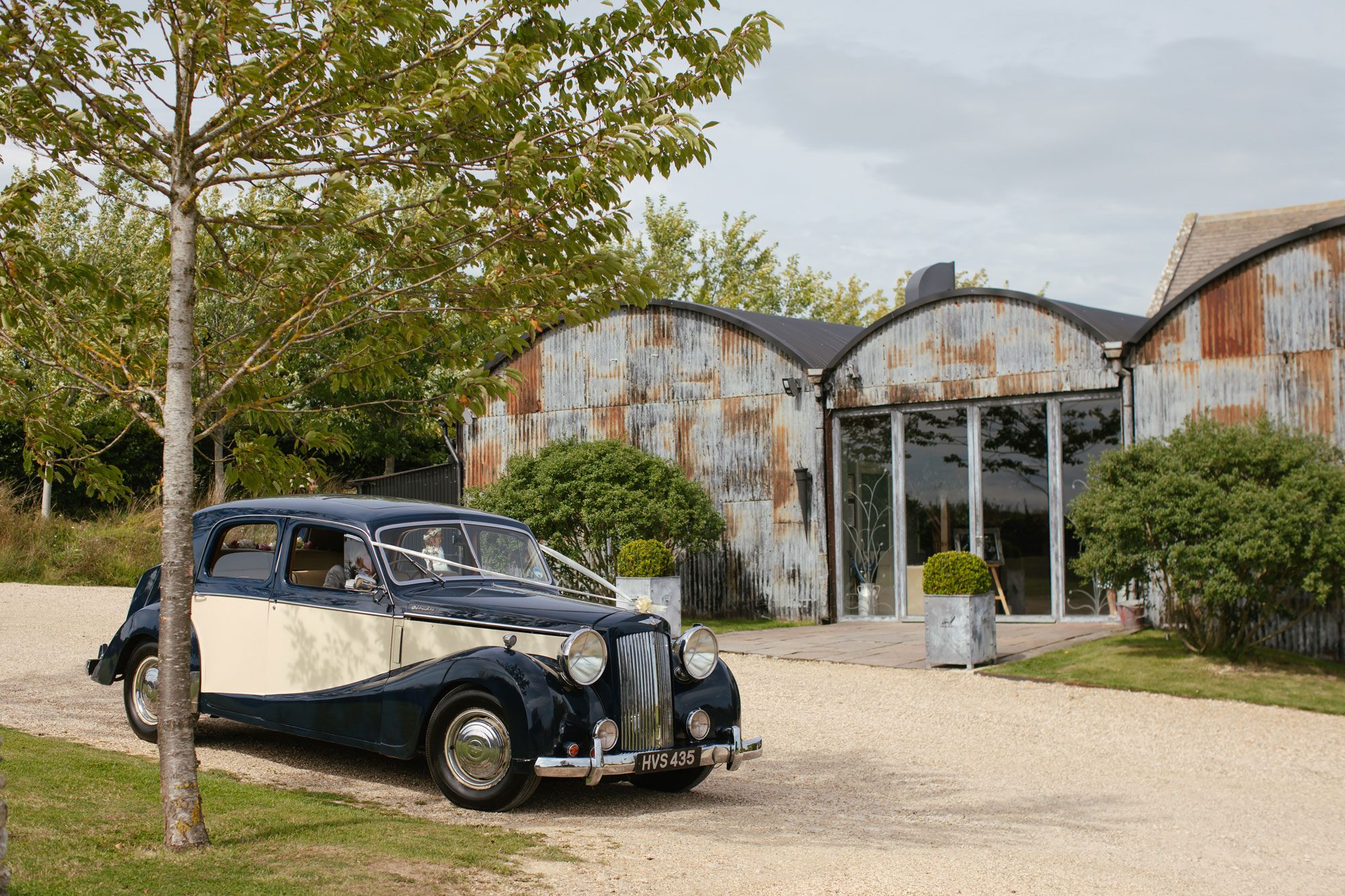 car at stone barn